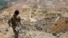 A Lebanese army member holds the remains of Israeli ammunition as he stands near the damage in the aftermath of Israeli air strikes near the border with Israel, Lebanon on Aug. 5, 2021.