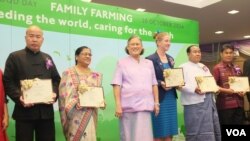 "Model" family farmers from China, India, New Zealand, Myanmar and Thailand hold their FAO citations as they pose with Princess Maha Chakri Sirindhorn.