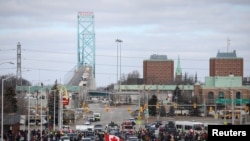 Para pengemudi truk dan para pendukungnya memblokir akses ke Jembatan Ambassador yang menghubungkan Detroit di AS dan Windsor di Kanada dalam demo memprotes aturan wajib vaksinasi COVID-19, di Windsor, Otario, Kanada, 12 Februari 2022. (Foto: Carlos Osorio/Reuters)
