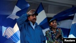 FILE - Nicaraguan President Daniel Ortega and Vice President Rosario Murillo gesture during a march called 'We walk for peace and life. Justice' in Managua, Nicaragua, Sept. 5, 2018. 