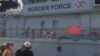 Residents of Lesbos peer into a British cutter that has been sent as part of a European Uunion force to assist Greece in returning migrants to Turkey, April 3, 2016.