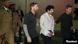 Sam Bankman-Fried, founder and former CEO of crypto currency exchange FTX, is walked in handcuffs to a plane during his extradition to the United States in Nassau, Bahamas Dec. 21, 2022. 