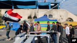 Protesters go through security inspection as they arrive to Tahrir Square, during ongoing protests, in Baghdad, Iraq, Dec. 25, 2019. 