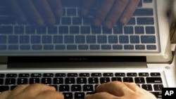 FILE - Hands type on a computer keyboard in Los Angeles.