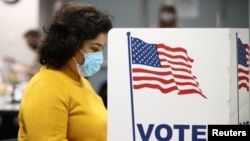 A woman fills in a ballot for the 2020 U.S presidential election in Fairfax, Virginia, November 3, 2020. 