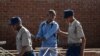 A man is arrested by police officers after resisting orders to vacate a vegetable market area in Bulawayo, Zimbabwe, March 31, 2020, on the second day of a lockdown to curb the spread of COVID-19.