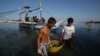 FILE - Filipino fishermen bring their fish to shore in the coastal town of Infanta, Pangasinan province, northwestern Philippines. 