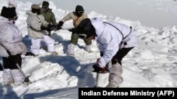 An Indian army soldier cuts through ice and snow in the search for survivors after a deadly avalanche on the Siachen Glacier, Feb. 8, 2016. An Indian soldier was rescued Monday, six days after being buried in the avalanche.