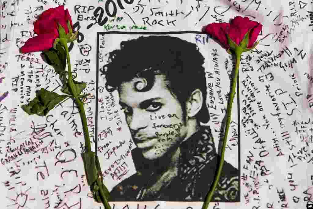 Flowers lay on a T-shirt signed by fans of singer Prince at a makeshift memorial place created outside the Apollo Theatre in New York. The pop star died Thursday at the age of 57.