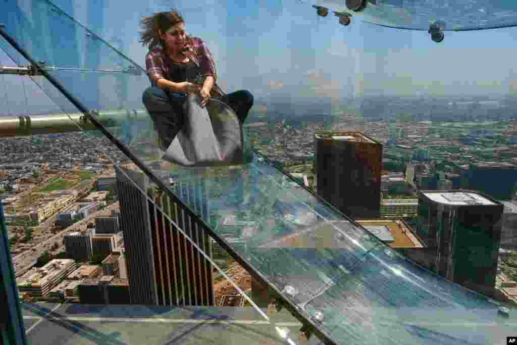 A member of the media rides down a glass slide during a preview at the U.S. Bank Tower building in downtown Los Angeles, June 23, 2016. Starting this weekend, thrill-seekers can begin taking the Skyslide, a 1,000-foot-high slide, perched on the outside of the tallest skyscraper west of the Mississippi. 
