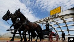 Kereta kuda yang membawa peti jenazah anggota Kongres AS dan tokoh hak-hak sipil, John Lewis, melintasi Jembatan Edmund Pettus dalam upacara perkabungan untuk Lewis, di Selma, Alabama, Minggu, 26 Juli 2020. 