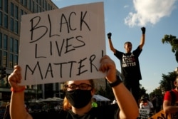 Demonstrators protest in front of a police line, June 24, 2020, in Washington.