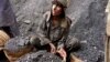 In this photo taken on June 30, 2010, a Pakistani mine worker waits for a help to load coal on a truck in Chamalang in Pakistan's Baluchistan province. This mine reopened with the army's help. (AP Photo/Sebastian Abbot)