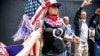 FILE - Conspiracy theorist QAnon demonstrators protest against coronavirus restrictions, in San Diego, California, May 01, 2020.