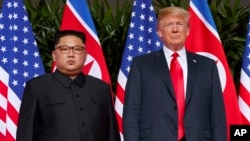 도널드 트럼프 미국 대통령과 김정은 북한 국무위원장이 지난 6월 싱가포르에서 열린 첫 미-북 정상회담에서 나란히 서있다.