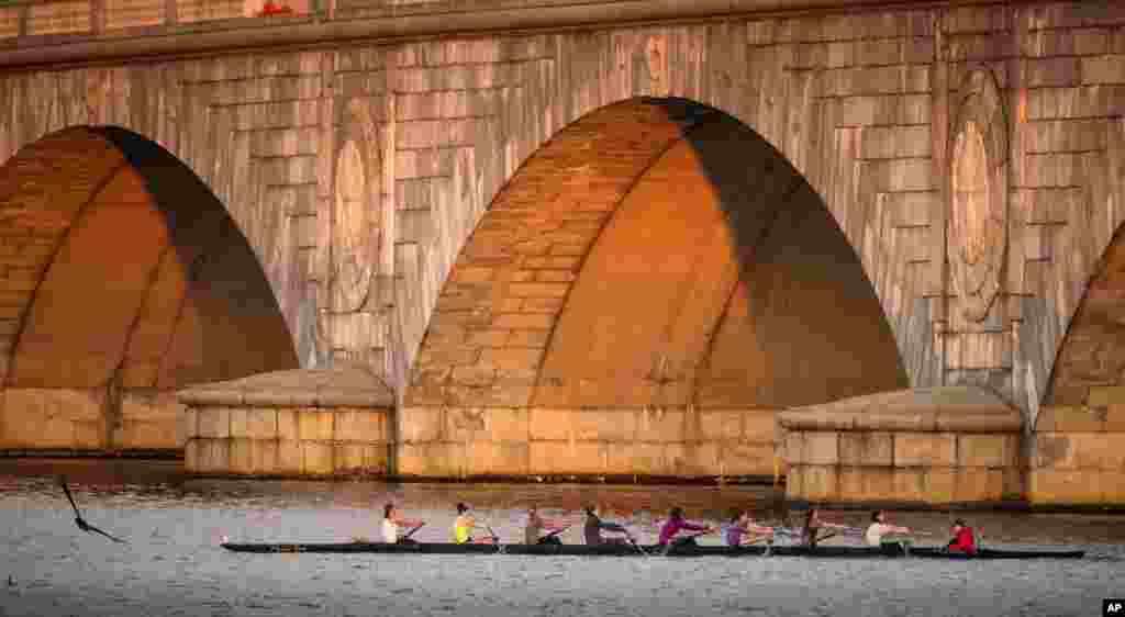 A rowing team passes the Memorial Bridge during practice on the Potomac River early in the morning in Washington.