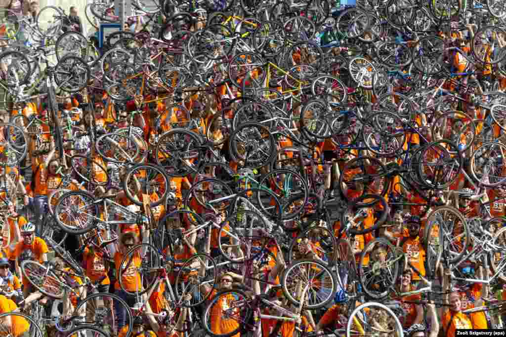 Thousands of cyclists raise their bikes during a march called "I Bike Budapest" in Budapest, Hungary, 23 April 2016. The mass parade was organized by the Hungarian Cyclists' Club to urge officials to build further tracks for cyclists in the streets and on the roads.