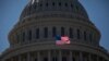 FILE - An American flag flies in front of the dome of the U.S. Capitol building, in Washington, July 26, 2011.