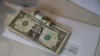Tips, money collected from a customer donation fund and a last paycheck for employees laid off from Farley’s East cafe, that closed due to the coronavirus outbreak, sits on a counter at the cafe in Oakland, California, March 18, 2020.