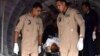 Egyptian military personnel help carry an injured 2nd Field Army solider into an ambulance, after a suicide bomber rammed his explosive-laden car into one of two buses carrying off-duty soldiers, killing at least 10 and wounding dozens more, security and 